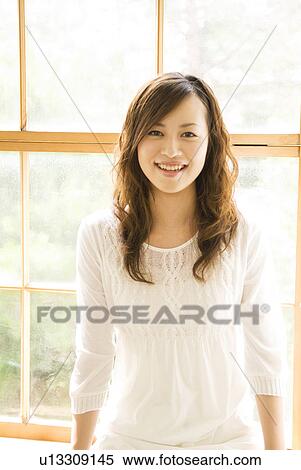 Woman sitting on window seat View Large Photo Image Stock Photography - Woman sitting on window seat. Fotosearch