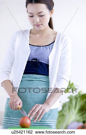 Stock Image - Woman slicing tomatoes. Fotosearch