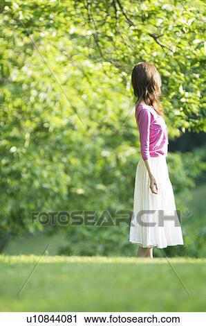 Stock Image - Woman standing in a field. Fotosearch