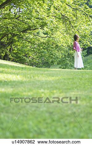Woman standing in a field View Large Photo Image Stock Image - Woman standing in a field. Fotosearch
