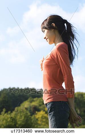 Stock Image - Woman standing in a field. Fotosearch