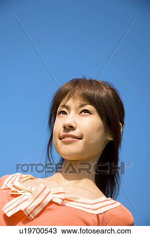 Stock Image - Woman standing in a field. Fotosearch