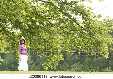 Stock Image - Woman standing in a field. Fotosearch