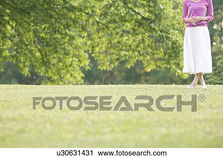Stock Image - Woman standing in a field. Fotosearch