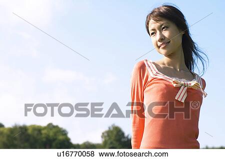 Woman standing in a field View Large Photo Image Stock Photo - Woman standing in a field. Fotosearch