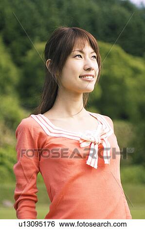 Stock Photograph - Woman standing in a field. Fotosearch