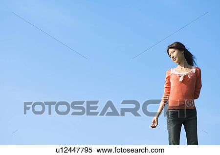 Woman standing in a field View Large Photo Image Stock Photography - Woman standing in a field. Fotosearch