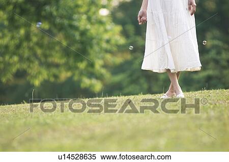 Stock Photography - Woman standing in a field. Fotosearch