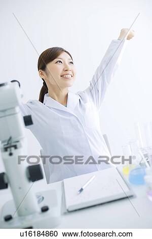 Woman stretching at her desk in a laboratory View Large Photo Image Stock Image - Woman stretching at her desk in a laboratory. Fotosearch