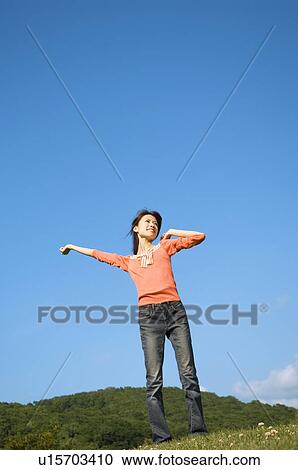 Woman stretching in a field View Large Photo Image Stock Image - Woman stretching in a field. Fotosearch
