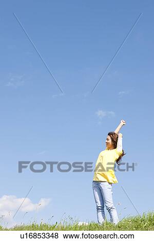 Woman stretching in a field View Large Photo Image Stock Photo - Woman stretching in a field. Fotosearch