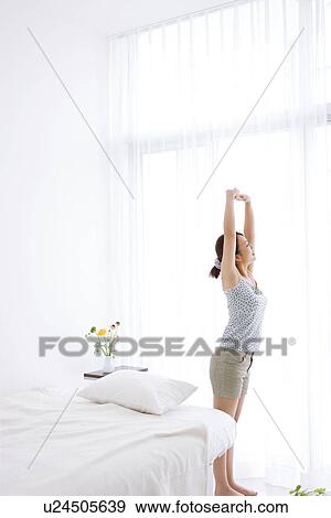 Woman stretching in bedroom View Large Photo Image Stock Photo - Woman stretching in bedroom. Fotosearch