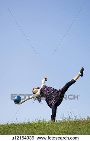 Woman stretching with ball on grass View Large Photo Image Stock Photograph - Woman stretching with ball on grass. Fotosearch