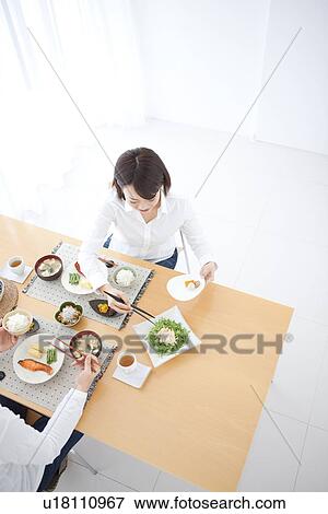 Stock Photo - Woman taking food (high angle view). Fotosearch