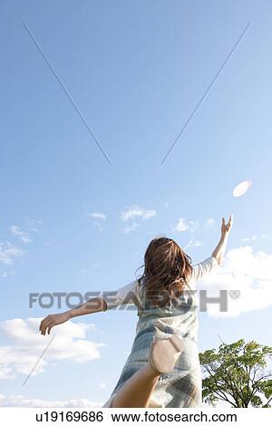 Stock Photograph - Woman throwing a frisbee. Fotosearch