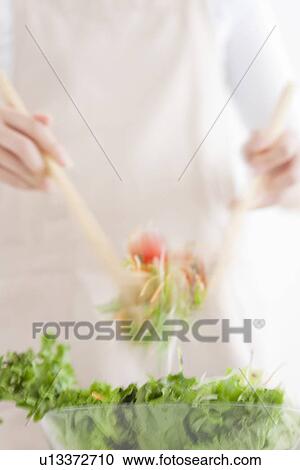 Stock Image - Woman tossing salad. Fotosearch