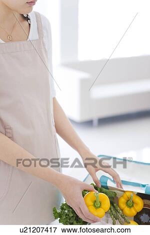 Stock Photo - Woman unpacking groceries from eco-bag. Fotosearch