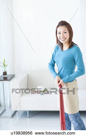 Woman vacuuming house View Large Photo Image Stock Photograph - Woman vacuuming house. Fotosearch