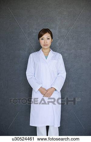 Stock Image - Woman wearing a lab coat. Fotosearch