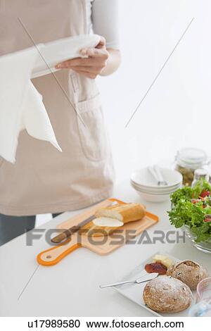 Stock Image - Woman wiping plate with cloth. Fotosearch