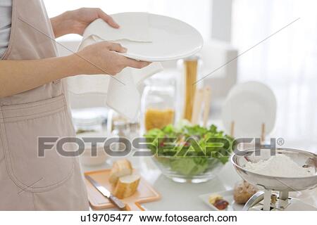 Stock Photo - Woman wiping plate with cloth. Fotosearch