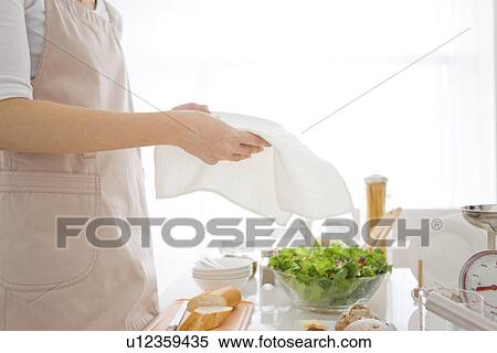 Stock Photography - Woman wiping plate with cloth. Fotosearch