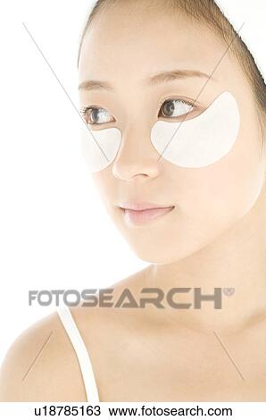 Stock Image - Woman with de-bag eye patches. Fotosearch