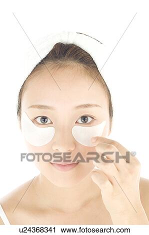 Stock Image - Woman with de-bag eye patches. Fotosearch