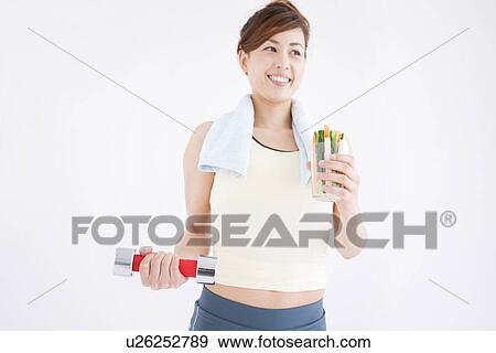 Woman working out and eating vegetable sticks View Large Photo Image Stock Photo - Woman working out and eating vegetable sticks. Fotosearch