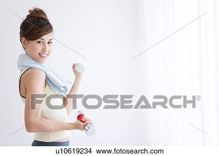 Woman working out at dumbbells View Large Photo Image Picture - Woman working out at dumbbells. Fotosearch
