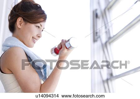 Picture - Woman working out at dumbbells. Fotosearch