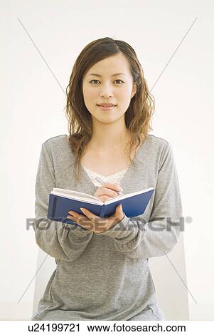 Stock Image - Woman writing in her diary. Fotosearch