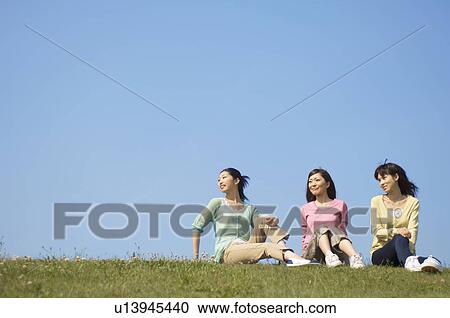 Women sitting on grass View Large Photo Image Stock Image - Women sitting on grass. Fotosearch
