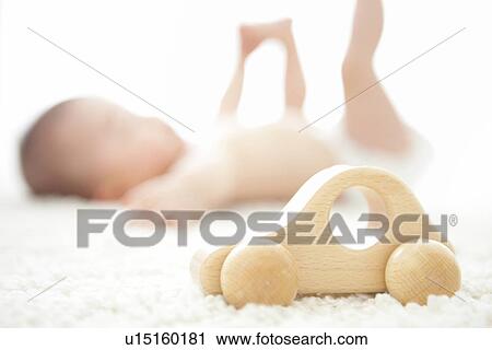 Stock Image - Wooden car and a baby in the background. Fotosearch
