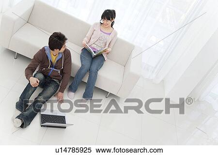 Young couple in living room with laptop View Large Photo Image Stock Photography - Young couple in living room with laptop. Fotosearch