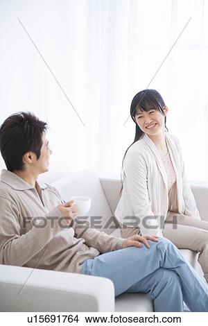 Young couple sitting on couch View Large Photo Image Picture - Young couple sitting on couch. Fotosearch