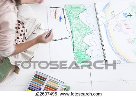 Stock Photography - Young girl drawing with crayons. Fotosearch