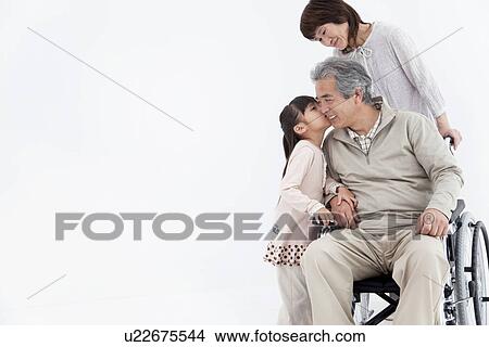 Picture - Young girl kissing grandfather on cheek. Fotosearch