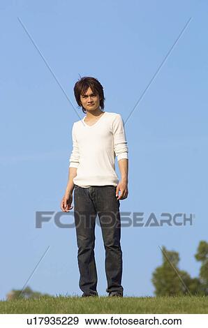 Stock Photo - Young man standing in field. Fotosearch