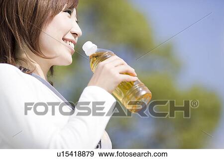 Stock Photo - Young woman drinking ice tea. Fotosearch