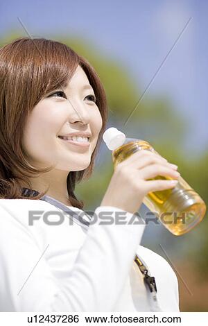 Stock Photograph - Young woman drinking ice tea. Fotosearch