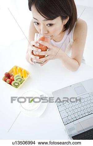 Picture - Young woman drinking vegetable juice. Fotosearch