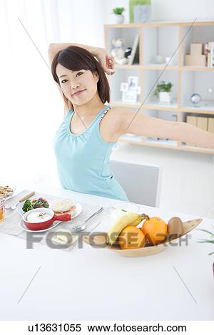 Stock Photography - Young woman having breakfast. Fotosearch
