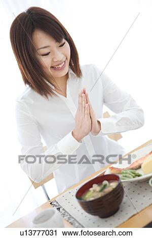 Young woman saying grace before a meal View Large Photo Image Stock Image - Young woman saying grace before a meal. Fotosearch
