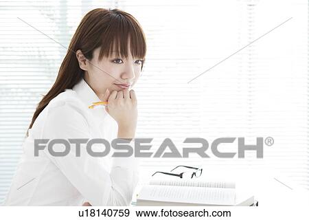 Stock Photo - Young woman studying at her desk. Fotosearch
