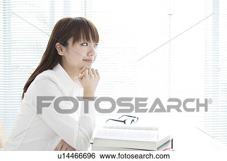 Stock Photograph - Young woman studying at her desk. Fotosearch