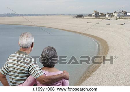 Couple standing with their arms around each other View Large Photo Image Stock Photo - Couple standing with their arms around each other. Fotosearch