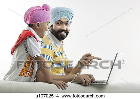Father showing something on his laptop to his son View Large Photo Image Picture - Father showing something on his laptop to his son. Fotosearch
