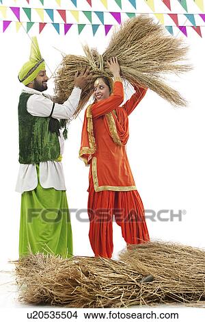 Man helping a woman carry a bale of hay View Large Photo Image Picture - Man helping a woman carry a bale of hay. Fotosearch