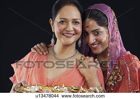Mother and daughter with a tray of diyas View Large Photo Image Picture - Mother and daughter with a tray of diyas. Fotosearch